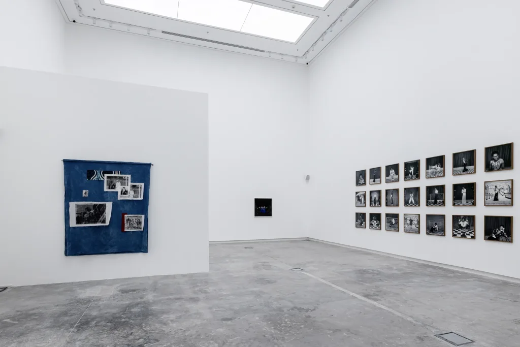 A minimalist white room featuring several framed pictures hanging on the walls.