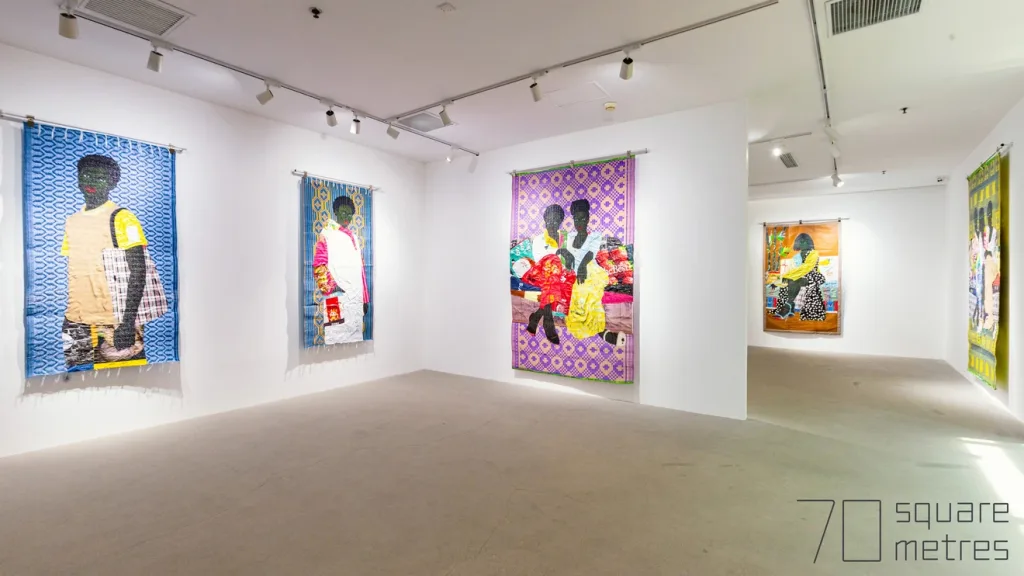Art gallery showcasing five artworks. Rich patterns and bold colors create a lively atmosphere, evoking cultural diversity.