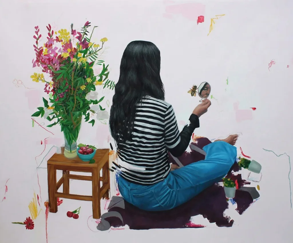 A person with long hair sits cross-legged, holding a mirror reflecting a bee. They wear a striped shirt and blue pants. Beside is a stool with flowers and red fruits, exuding calm and introspection.